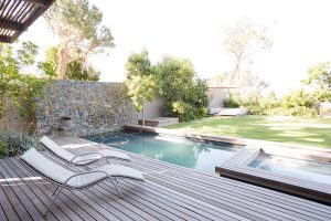 Lawn chairs and swimming pool in backyard